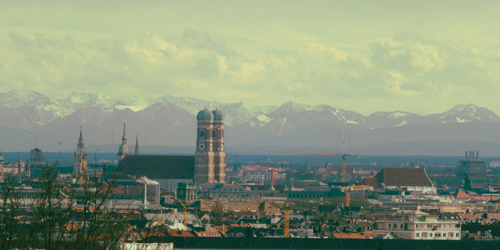 Blick über München mit Frauenkirche und den Alpen im Hintergrund
